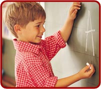 photo: young boy standing at a chalk board